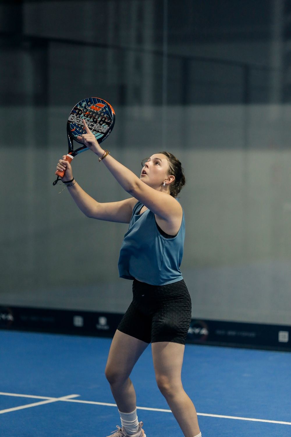 Atleta preparando o saque em quadra de padel