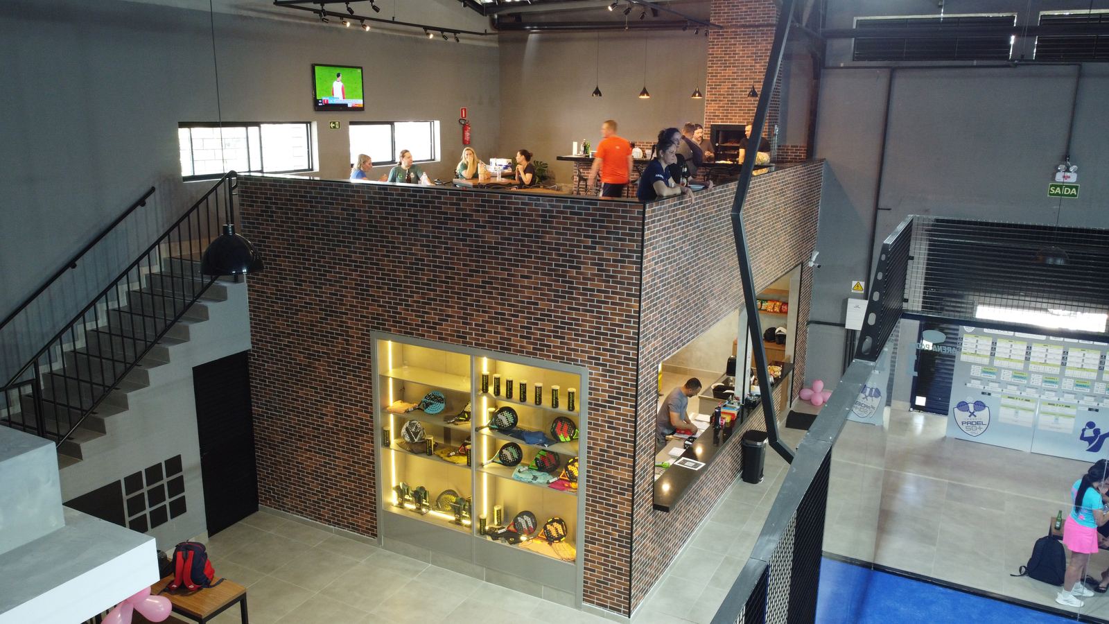 Mezanino da Arena Padel CWB, com vitrine e escada de acesso